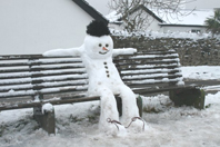 Photo of a snowman sitting on a Bench